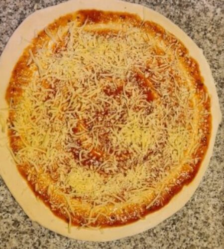 Pizzateig wird mit leckerem Käse belegt
